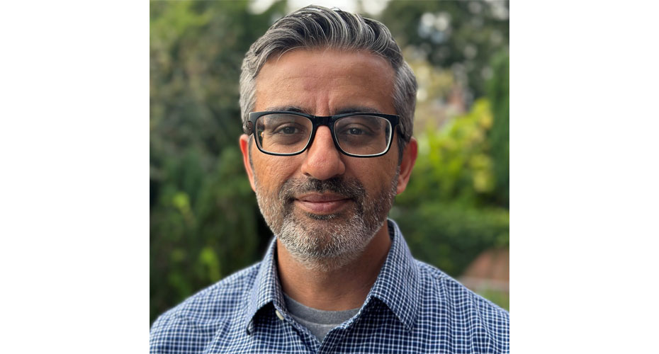 Man in glasses in front of shrubbery